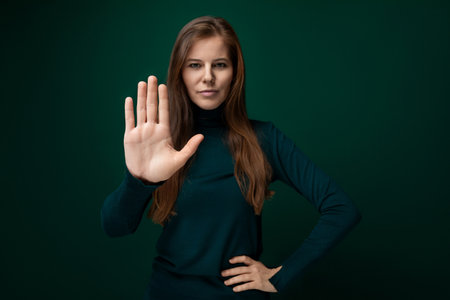 Caucasian young woman with brown eyes actively shows stop gestureの写真素材