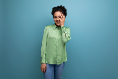 young female model with curly black hair dressed in trendy shirt isolated background with copy spaceの写真素材