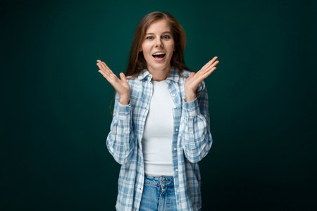 Smiling cute european woman looking friendly at camera on green studio background