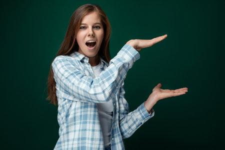30 year old cheerful young lady with gorgeous long brown hair on a green backgroundの写真素材