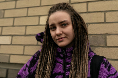 Stylish informal woman with dreadlocks wearing a purple jacket, lifestyle conceptの写真素材