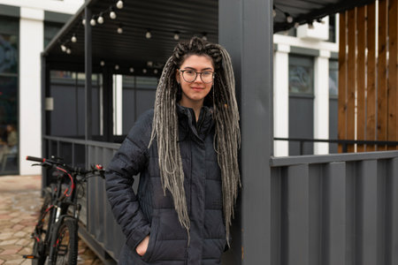 Urban charming woman with dreadlock hairstyle walks around the city at lunchtimeの写真素材