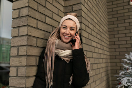 Young pretty woman with blond dreadlocks wearing a black winter coat