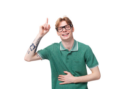 portrait of a young energetic man with red hair pointing fingers up for having an ideaの写真素材
