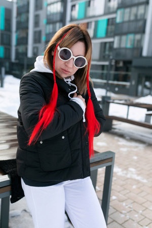 Carefree young woman walking down the street in winter weather and happyの写真素材