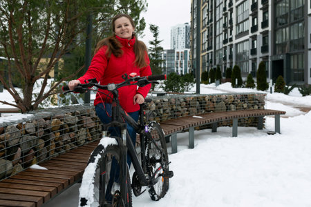 Young woman riding a bicycle in the city in winterの写真素材