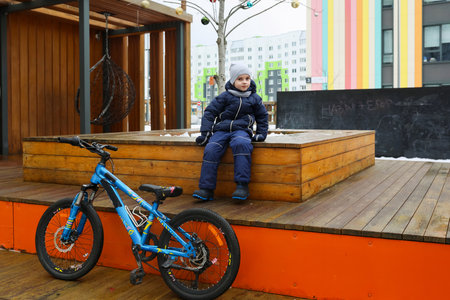 Caucasian boy is tired from cycling and is restingの写真素材