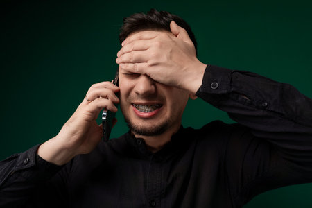 Man Holding Cell Phone to Earの写真素材