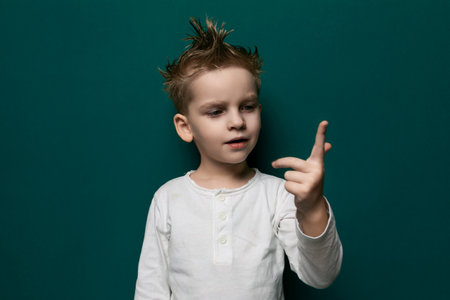 Little Boy With Mohawk Pointing at Camera