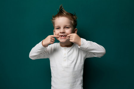Little Boy Standing in Front of Green Wallの写真素材