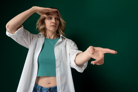 Woman in Green Shirt Pointing at Somethingの写真素材