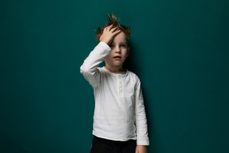Little Boy Standing Against Green Wallの写真素材