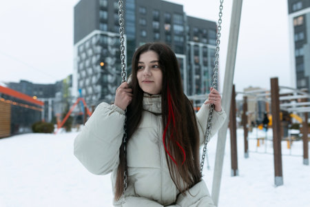 Woman Sitting on Swing in Snowの写真素材