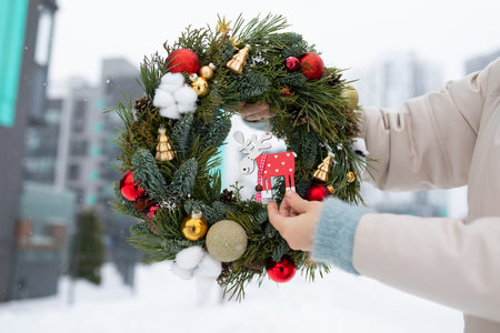 Person Holding Christmas Wreath in Snowの写真素材