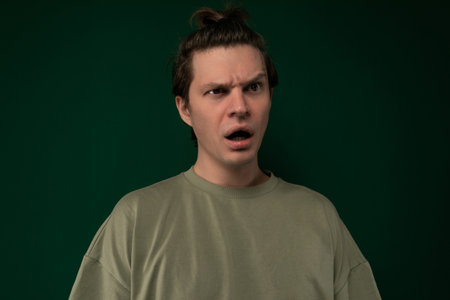 Man Making Surprised Face Against Green Backgroundの写真素材