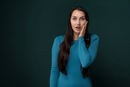 Woman in Blue Dress Holding Hand to Face