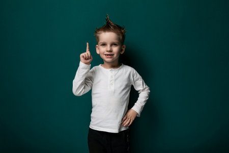 Little Boy Standing in Front of Green Wall