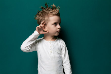 Young Boy With Mohawk Standing Against Green Wallの写真素材