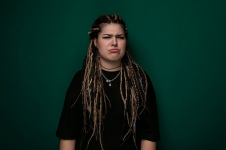 Woman With Dreadlocks Standing in Front of Green Wall