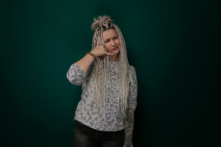 Woman With Long Blonde Hair Standing in Front of Green Wall