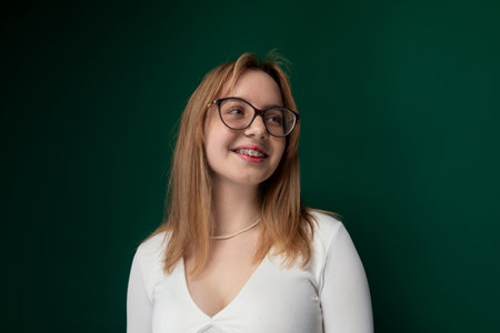 Woman Wearing Glasses Standing in Front of Green Wallの写真素材