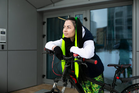 Woman in Black Jacket and Yellow Safety Vest Riding Bicycleの写真素材
