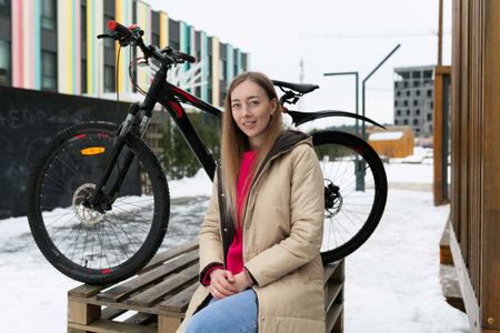 Woman Sitting on Bench Next to Bicycleの写真素材
