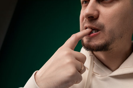 Man Holding Finger to Nose