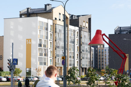 Modern high-rise apartment buildings in a vibrant residential area with unique street lamp design, showcasing urban living and architectureの写真素材