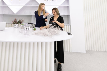 Floral arrangement workshop taking place in a modern studio with two participants creating designsの写真素材