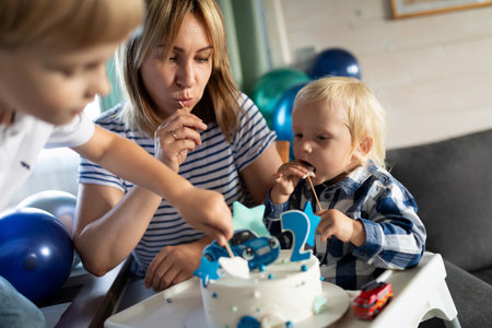 Celebration with young children and a cake at a birthday party at home in the afternoon