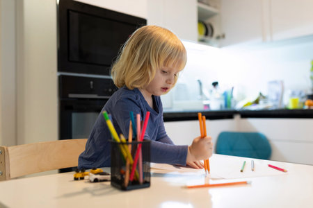 Child engaged in creative drawing activity at home during the daytimeの写真素材