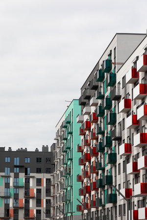 Modern high-rise apartment buildings in a residential area, showcasing diverse architecture and colorful balconies on an overcast dayの写真素材