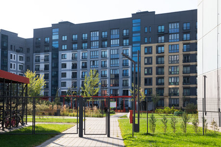 Modern high-rise apartment buildings in a residential area showcasing green spaces and amenities for renters and homeownersの写真素材