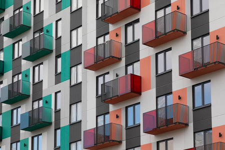 Colorful high-rise apartment buildings in a modern residential area showcasing various balcony designs and architectureの写真素材