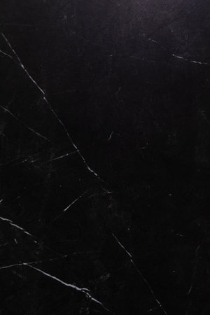 Dark marble surface with white veining providing a luxurious backdrop for various designs and decorの写真素材