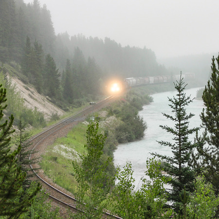 Train Along Mountain River in Fogの写真素材