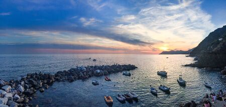 Panoramic view of the harbour and breakwater of Riomaggiore in Cinque Terre at sunset.の写真素材