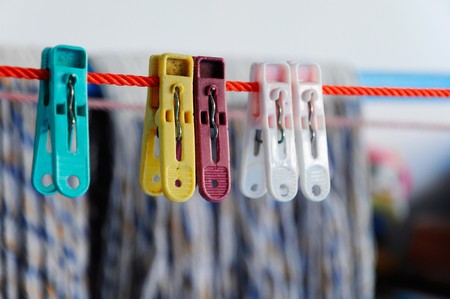 Colorful clothes peg on the red lineの写真素材
