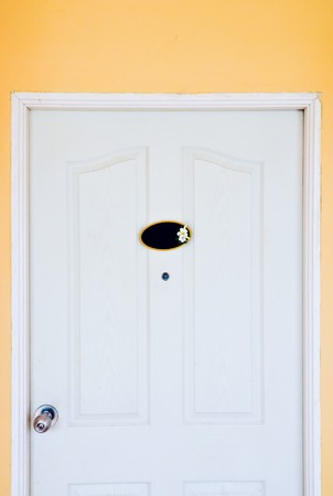 White classic door on the orange wall of hotelの写真素材