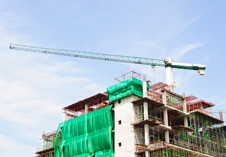 The green crane on top of a building under construction in the capital.のeditorial素材