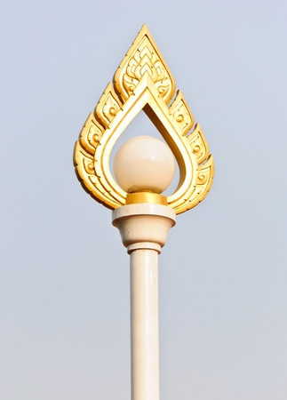 Golden lantern poles with traditional Thai sculpture in the park の写真素材