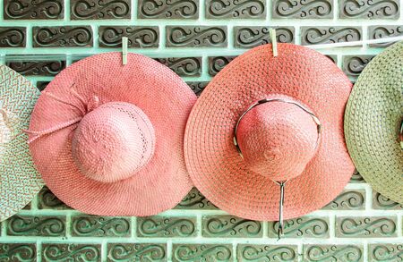 Colorful woven hat hanging on the wall of souvenir shop の写真素材