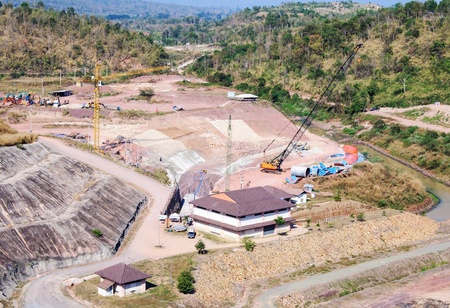 Construction site for building the large dam in valley.