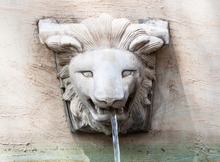 Lion head fountain in European style on the old wall の写真素材