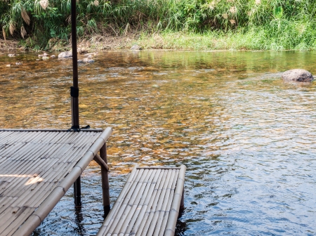 Bamboo table of local restaurant in the clear river の写真素材
