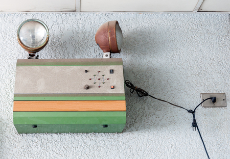 Old emergency light is hanging on the office wall.の写真素材