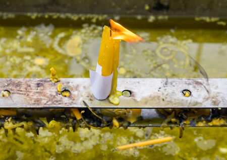 Single candle on the metal holder in Thai temple.の写真素材