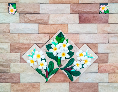 White plumeria stucco on the sand tile wall.の写真素材