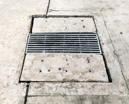 Old drain cap on the cement road in urban village.